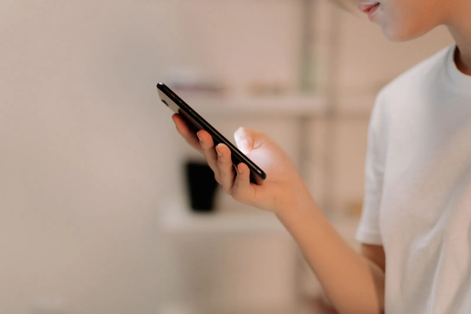 A person holding a smartphone and reading something on the screen