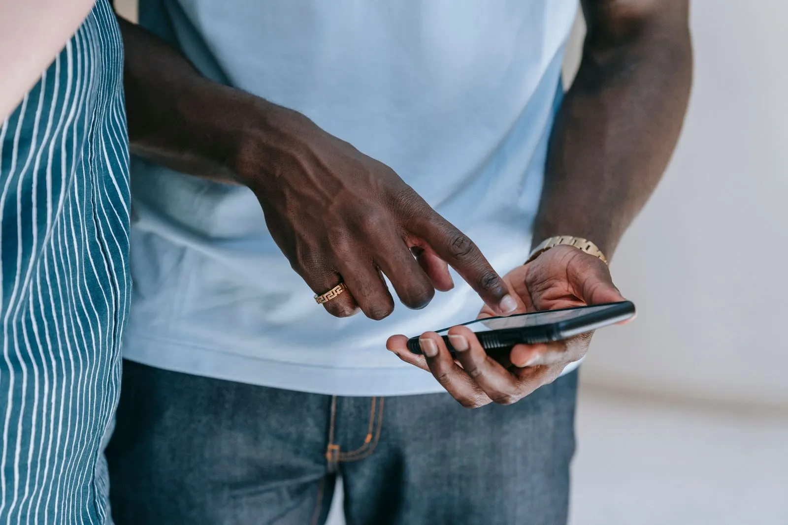 Close-up of two hands tapping on a smartphone screen