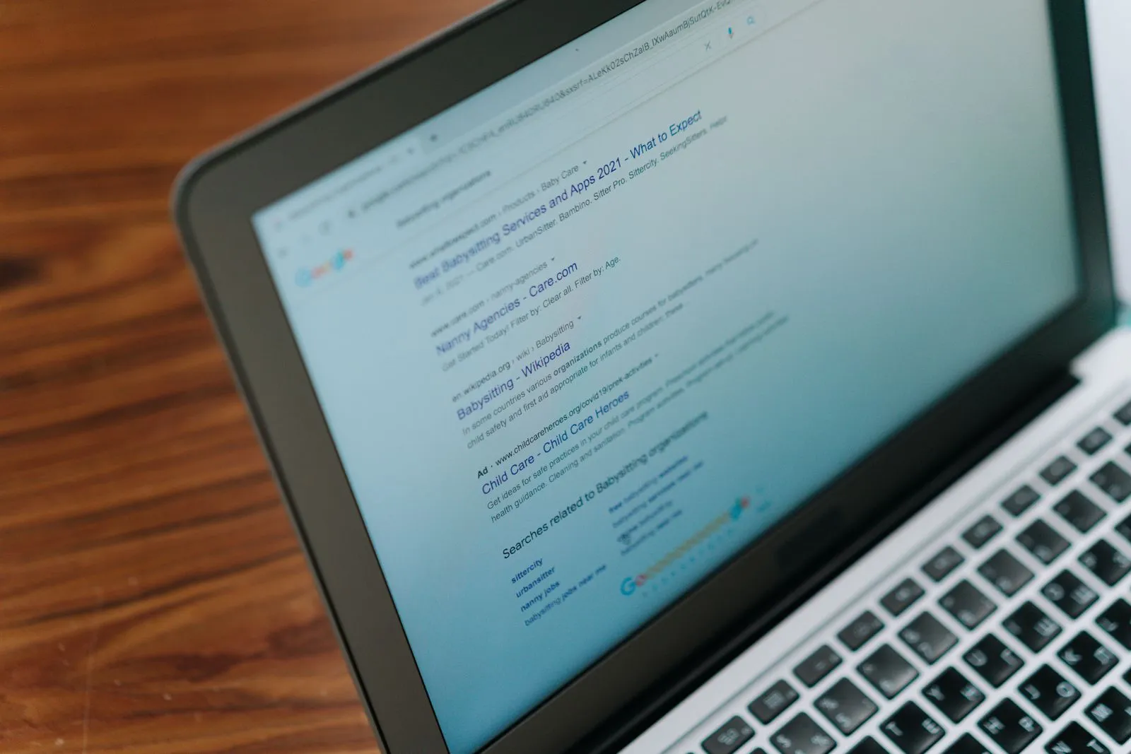 Laptop showing an open Google results page on a wooden table